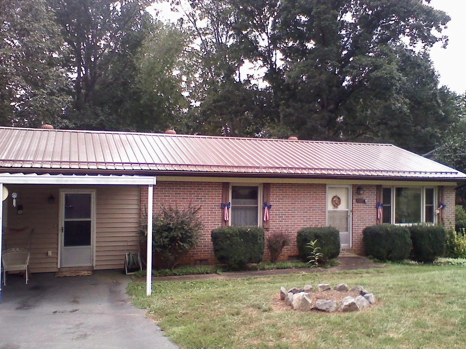 Bronze metal roof and carport on a brick ranch home — Roof Repair work by our crew in Elmira